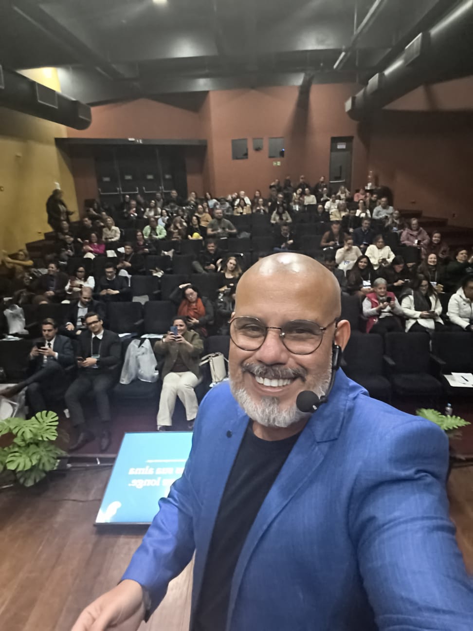 Fabio Vasconcelos no palco em auditório lotado, de frente para a plateia