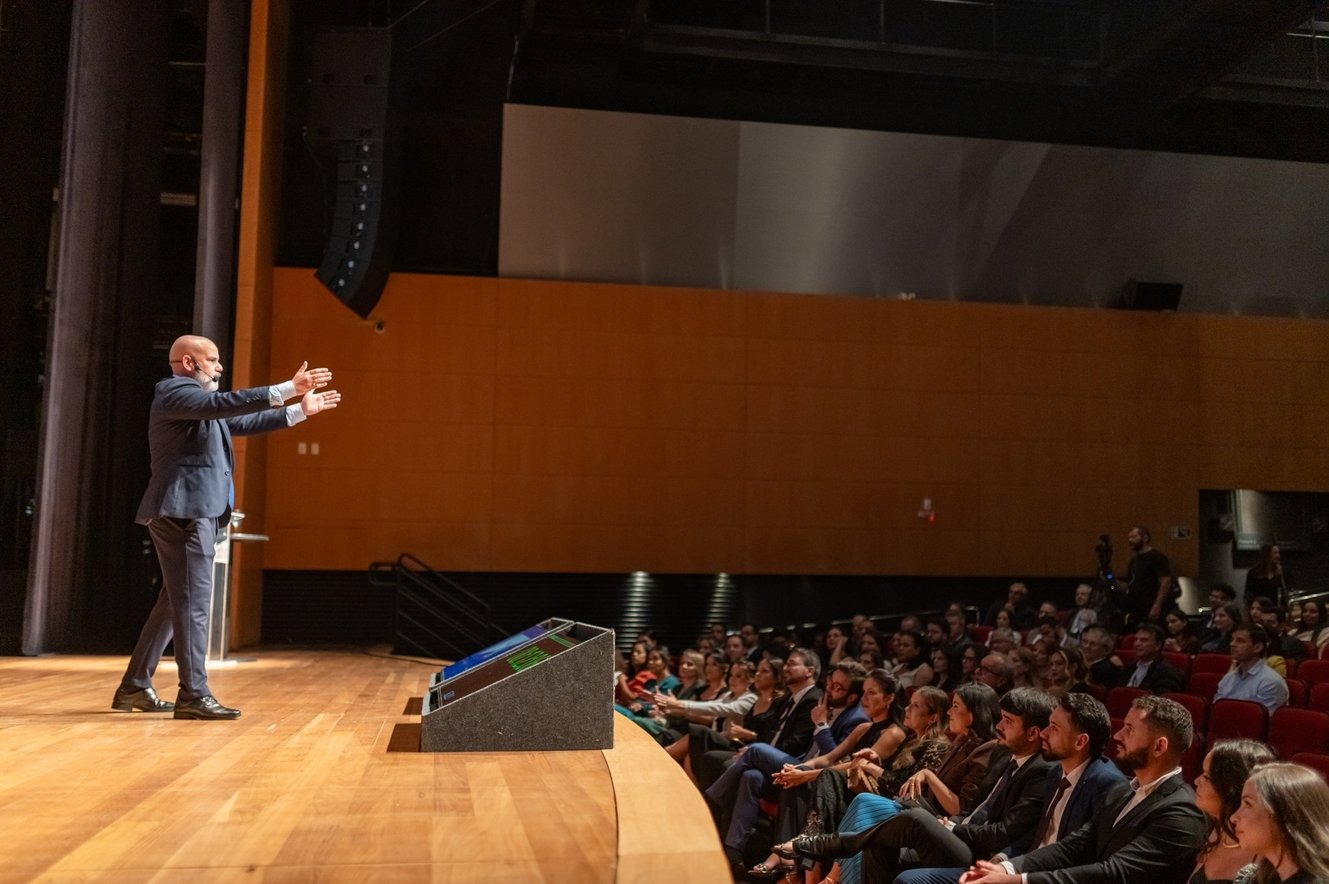 Fabio Vasconcelos palestrando em auditório corporativo lotado